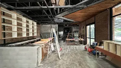 Spacious industrial-style interior under construction with exposed brick and modern design elements.