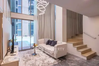 Luxurious modern living room with elegant staircase and pool view, featuring chic decor and ample natural light.