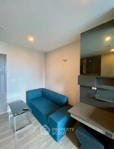 Modern living room with sleek blue sofa and stylish wall clock
