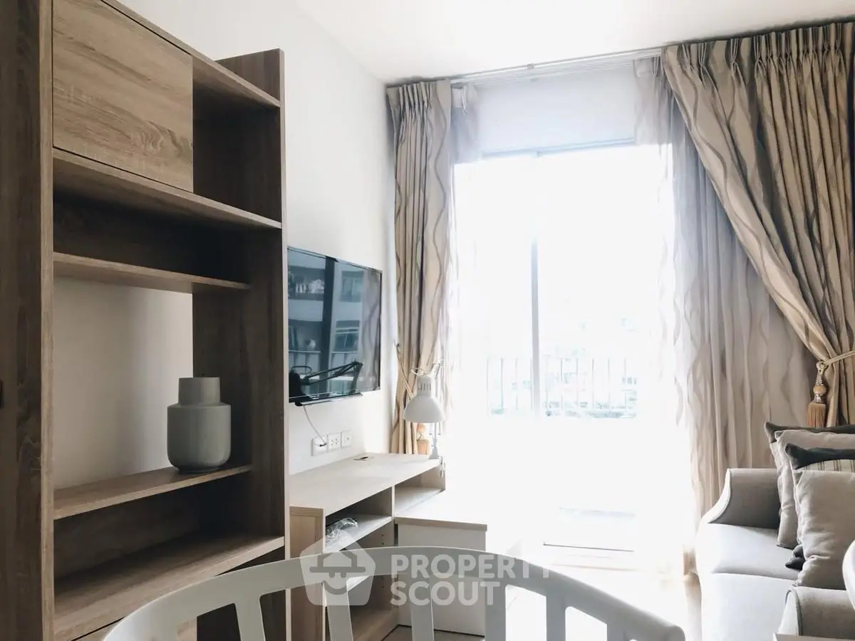 Bright living room with modern decor and large window in a stylish apartment.