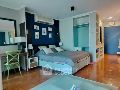 Spacious bedroom with modern decor and ample storage in a stylish apartment.