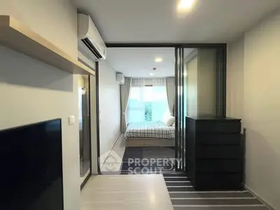 Modern apartment interior with sliding glass doors leading to a cozy bedroom, featuring sleek furniture and natural light.