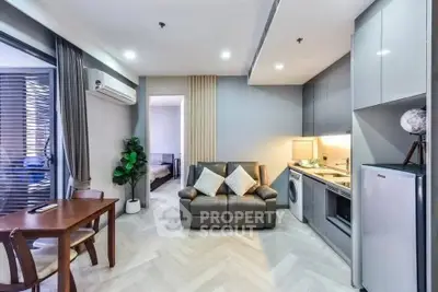 Modern open-plan living room with sleek kitchen and cozy seating area in stylish apartment.