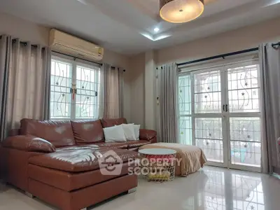 Spacious living room with leather sofa and large windows in modern apartment