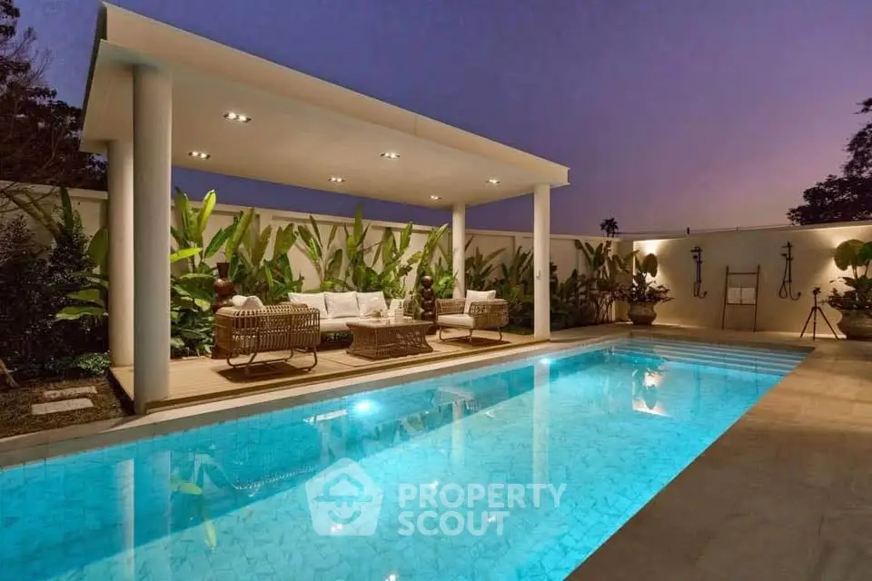 Luxurious backyard pool with elegant seating area and ambient lighting at dusk