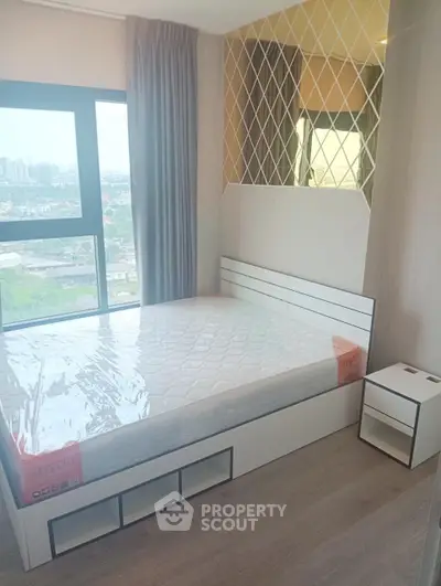 Modern bedroom with large window offering stunning city views and stylish decor.