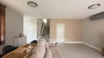 Spacious living room with modern decor and staircase in a stylish home