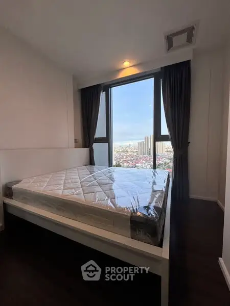 Modern bedroom with large window offering stunning city view