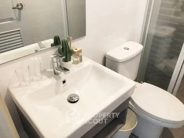 Modern bathroom with sleek sink and shower, ideal for compact spaces.