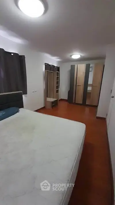 Spacious bedroom with modern furniture and ample storage space.
