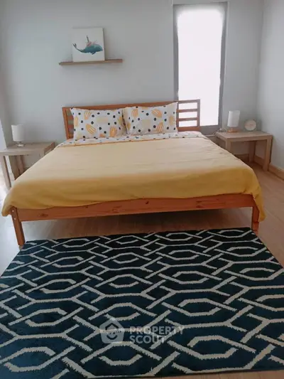 Cozy bedroom with modern decor and stylish geometric rug, perfect for relaxation and comfort.