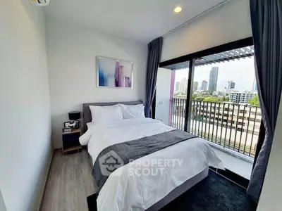 Modern bedroom with city view and balcony access in a stylish apartment.