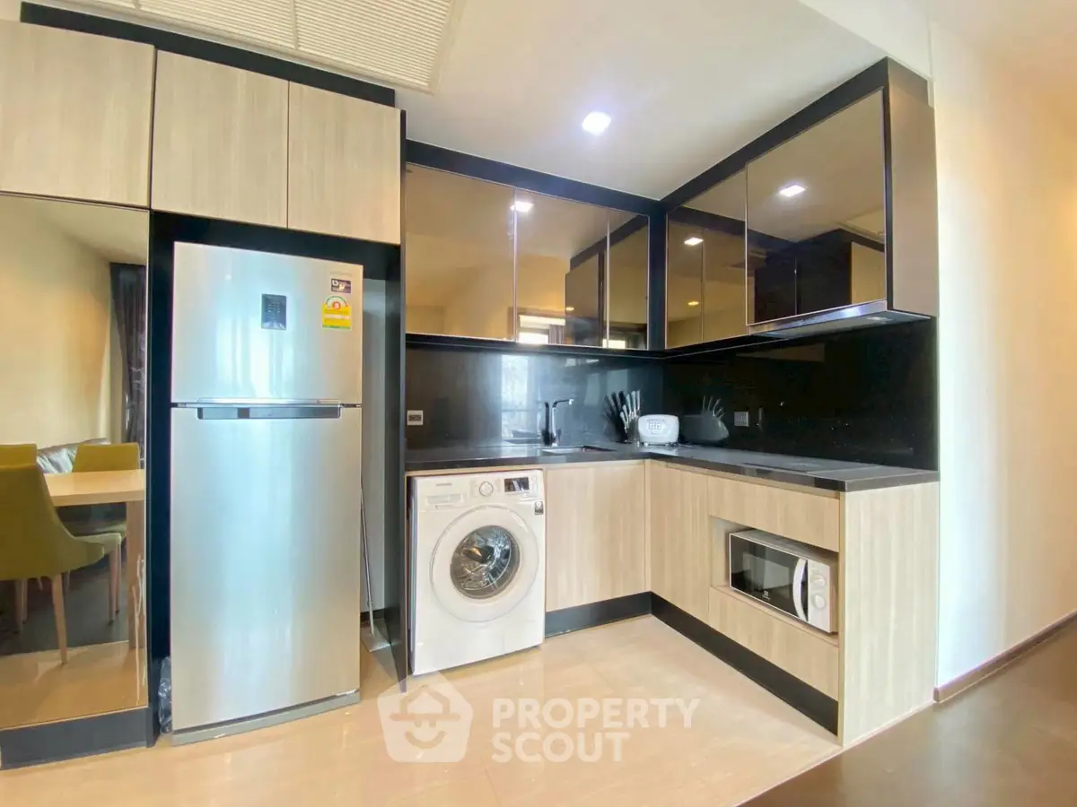 Modern kitchen with sleek appliances and stylish cabinetry in a contemporary apartment.