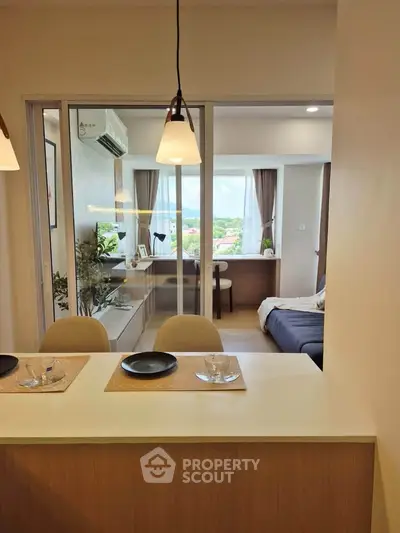 Modern open-plan living room with dining area and scenic view, featuring stylish decor and natural light.
