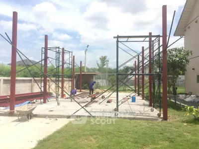 Construction site with steel framework and workers under a clear sky