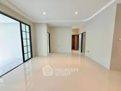 Spacious modern living room with sleek tile flooring and ample natural light.