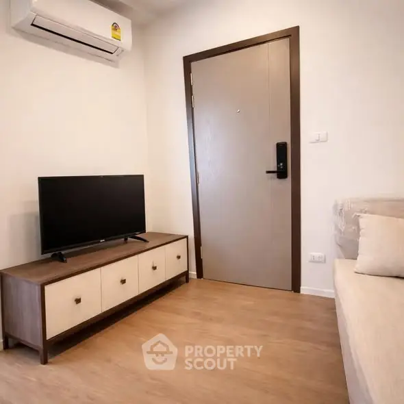 Modern living room with TV, air conditioning, and stylish furniture