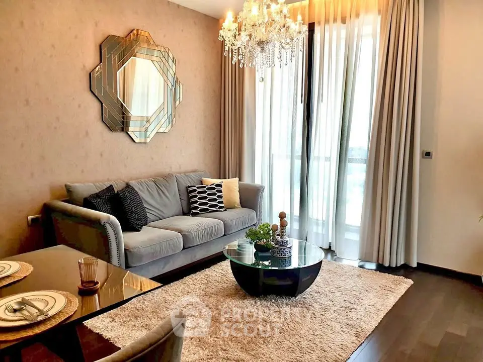 Elegant living room with chandelier, plush sofa, and stylish decor in modern apartment.