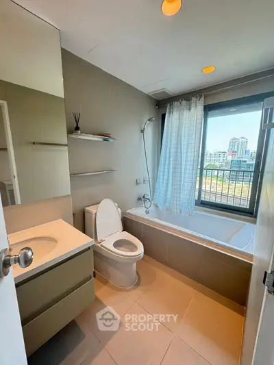 Modern bathroom with city view, featuring a bathtub and sleek fixtures.