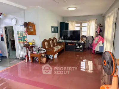 Spacious living room with tiled floor, large windows, and traditional wooden furniture.