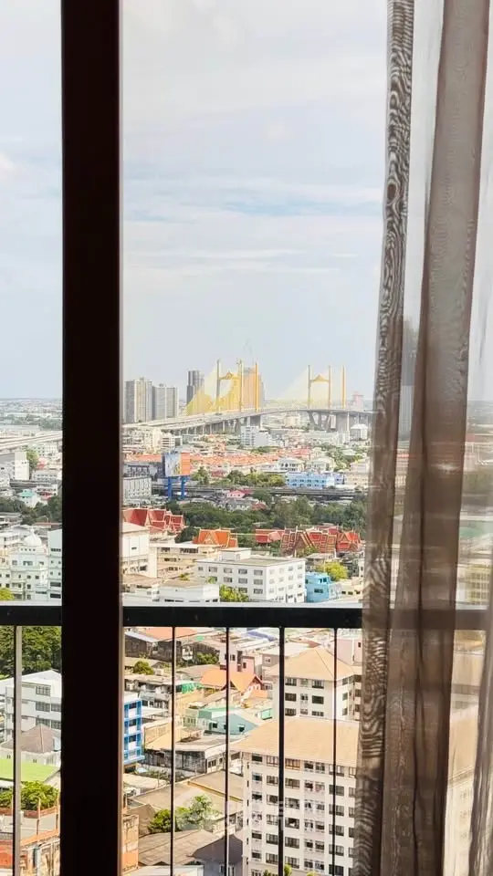 Stunning cityscape view from a high-rise balcony with iconic bridge in the background.