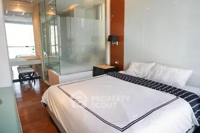 Modern bedroom with glass partition and wooden flooring in luxury apartment