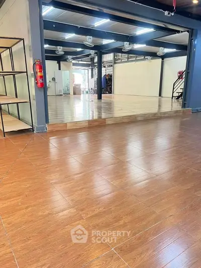 Spacious commercial interior with wooden flooring and modern design, ideal for business setup.