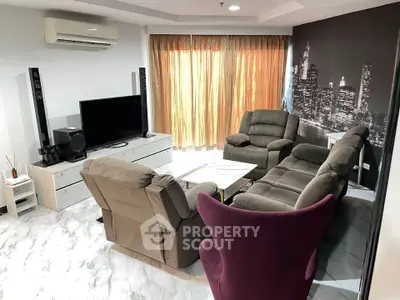 Spacious living room with modern furniture and cityscape wall art, featuring a cozy seating area and large TV.