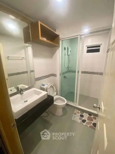 Modern bathroom with glass shower and sleek fixtures in a contemporary apartment.
