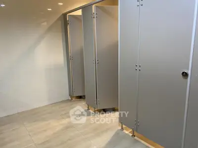 Modern public restroom with sleek stall design and tiled flooring