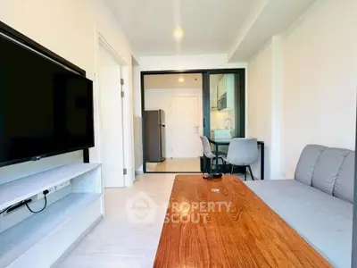 Modern living room with sleek furniture and open kitchen layout in a stylish apartment.