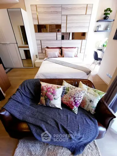 Stylish modern bedroom with cozy sofa and elegant decor in a chic apartment setting.