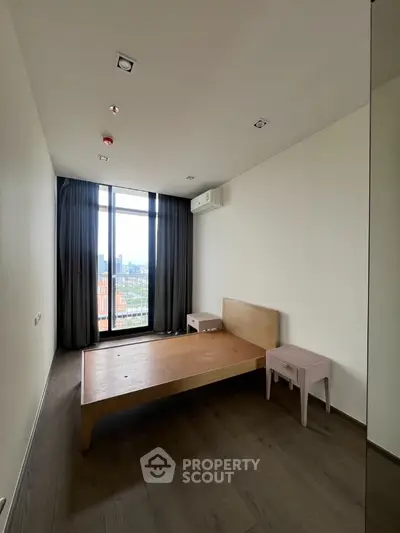 Minimalist bedroom with wooden bed frame and city view window