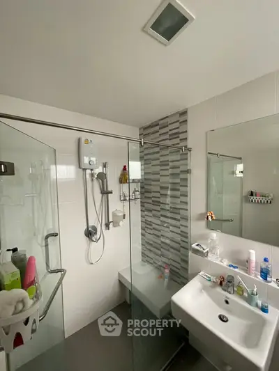 Modern bathroom with glass shower enclosure and sleek fixtures