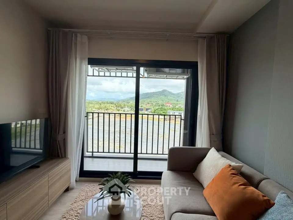 Cozy living room with stunning mountain view from balcony, featuring modern sofa and TV unit.