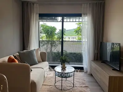 Chic living room with cozy sofa, modern TV setup, and scenic balcony view.