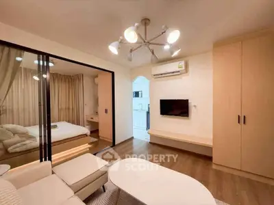Modern living room with cozy seating and view into a stylish bedroom