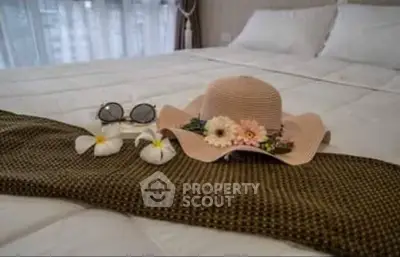 Cozy bedroom with elegant decor, featuring a stylish hat and sunglasses on a neatly made bed.