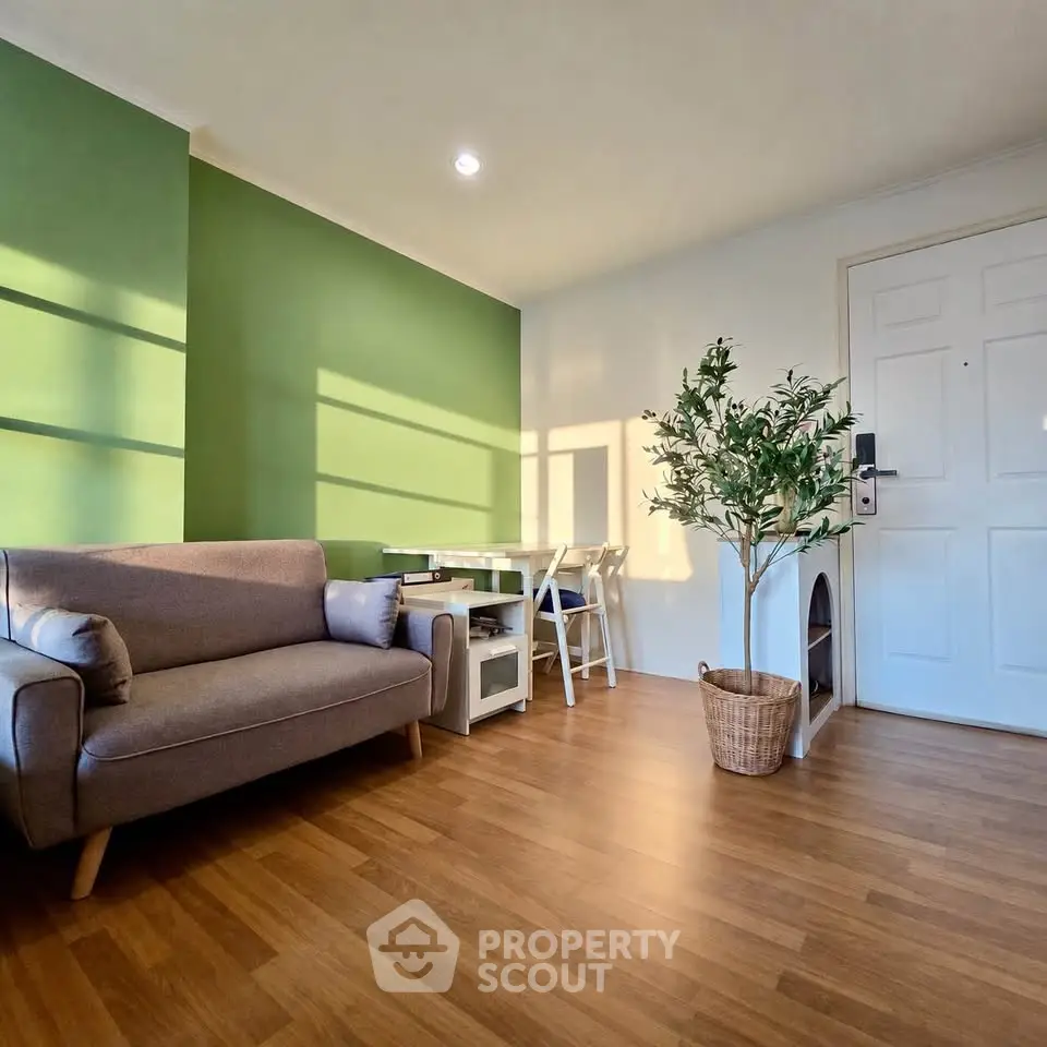 Charming living room with green accent wall and cozy furniture, perfect for relaxation.