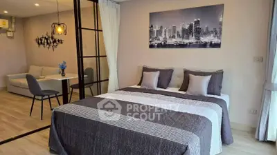 Modern bedroom with stylish decor and cozy living area in open layout apartment.