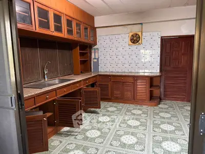 Spacious kitchen with wooden cabinets and tiled floor in a cozy home