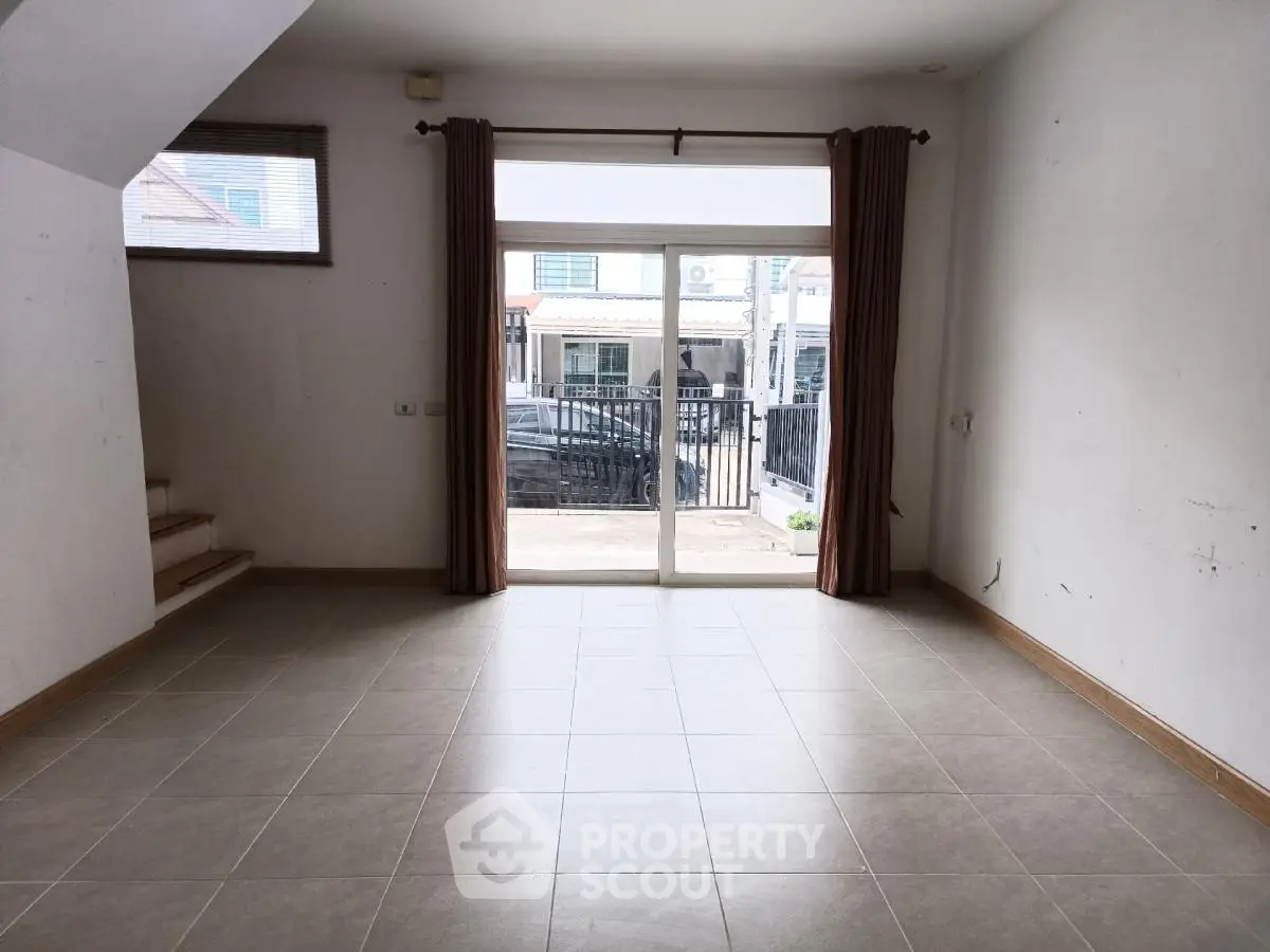 Spacious unfurnished living room with large window and tiled floor