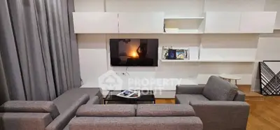 Modern living room with sleek gray sofas and wall-mounted TV, perfect for relaxation and entertainment.