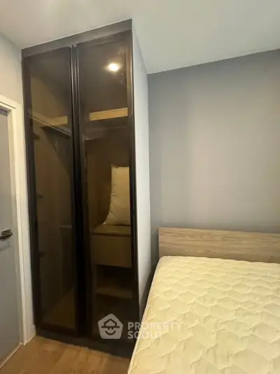 Modern bedroom with sleek wardrobe and comfortable bed in stylish apartment.
