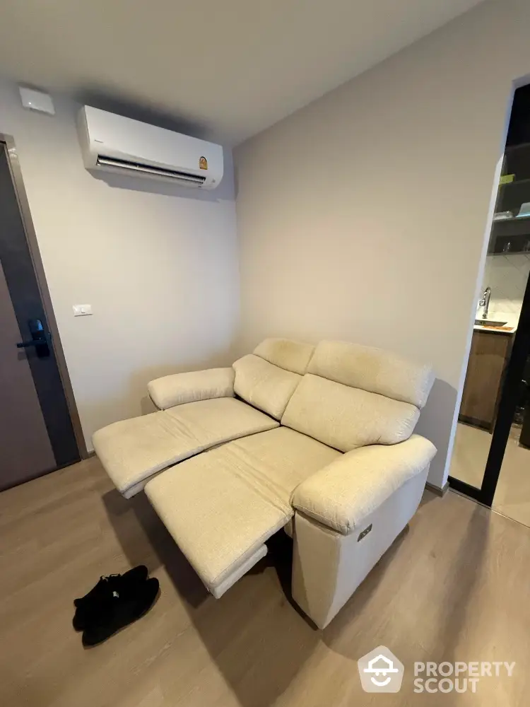 Cozy living room with reclining sofa and modern air conditioning unit