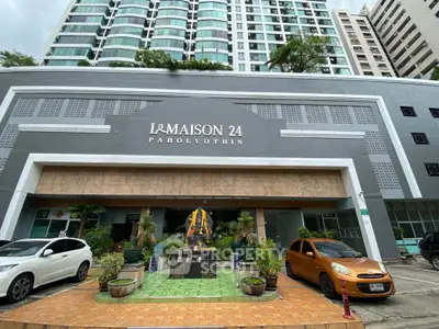 Modern condominium entrance with stylish facade and parked cars at La Maison 24 Paholyothin.