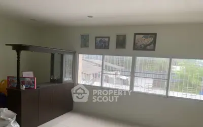 Bright room with large windows and decorative wall art, offering a spacious and inviting atmosphere.