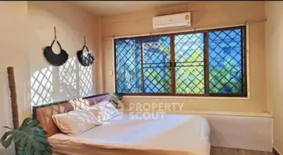 Cozy bedroom with large windows and air conditioning in a serene setting