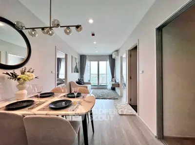 Modern open-plan living and dining area with stylish decor and balcony view.