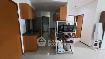 Modern kitchen with wooden cabinets and sleek appliances in a spacious apartment.